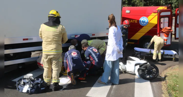 Com o impacto, motociclista foi parar embaixo do caminhão.