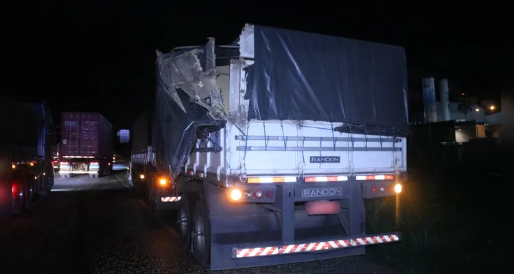 Carreta atingida teve danos e parte da carga de soja caiu na pista.