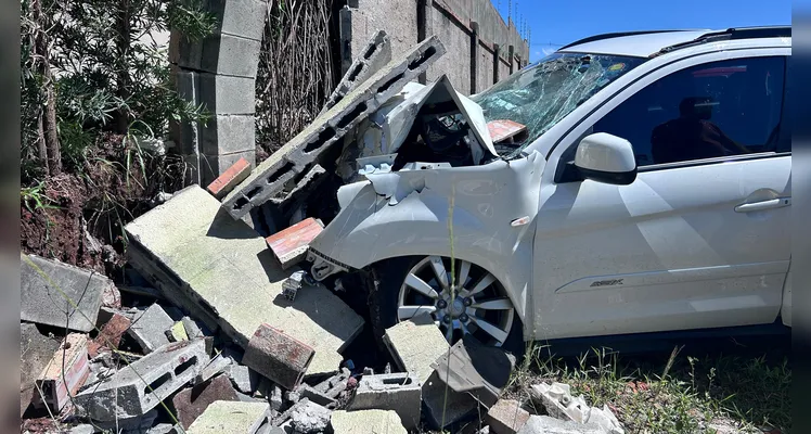 Carro atingiu o muro de um condomínio.