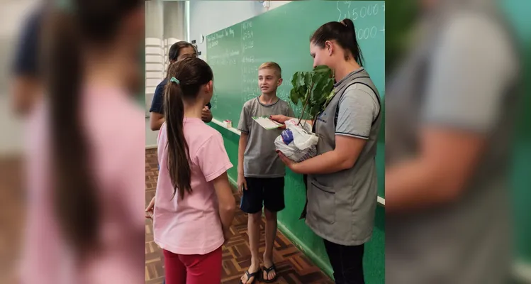 A turma realizou a entrega de mudas de árvores, simbolizando o compromisso com o cuidado com a natureza.