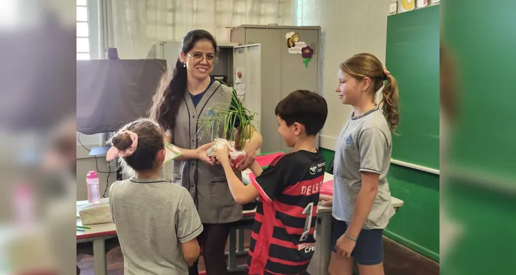 A turma realizou a entrega de mudas de árvores, simbolizando o compromisso com o cuidado com a natureza.