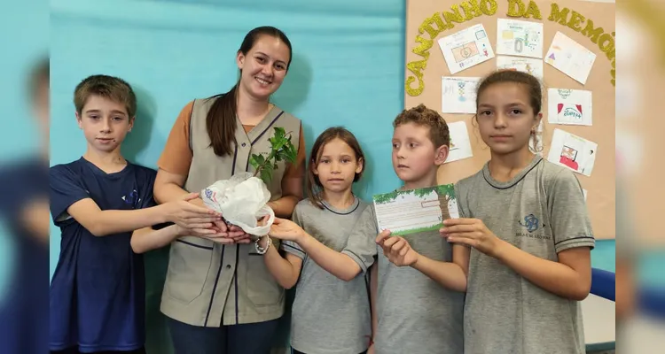 A turma realizou a entrega de mudas de árvores, simbolizando o compromisso com o cuidado com a natureza.