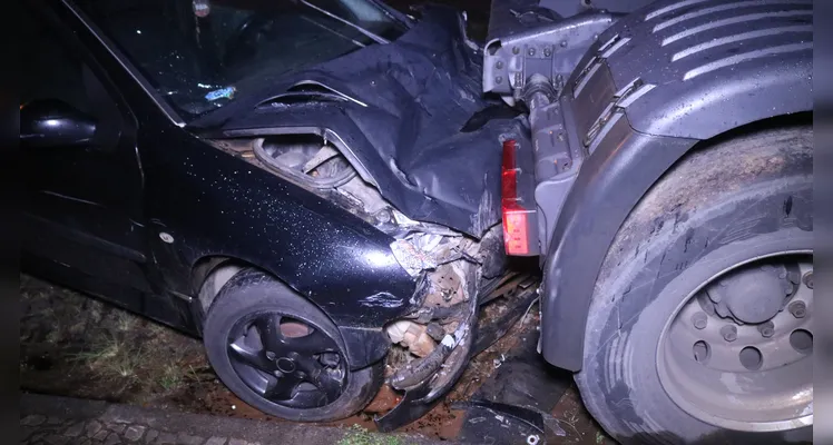 Carro bate em traseira de caminhão estacionado e causa prejuízos ao proprietário. Acidente aconteceu em Uvaranas, na noite deste sábado (11) |