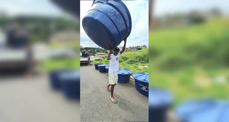 Morador carregando uma caixa d'água nas costas.