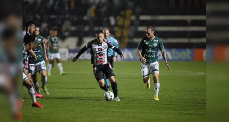 Meio-campista Reina em disputa contra jogadores do Guarani.