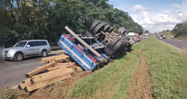 Carreta que transportava uma carga de madeira seguia pela estrada no sentido Curitiba, quando tombou e invadiu a pista contrária