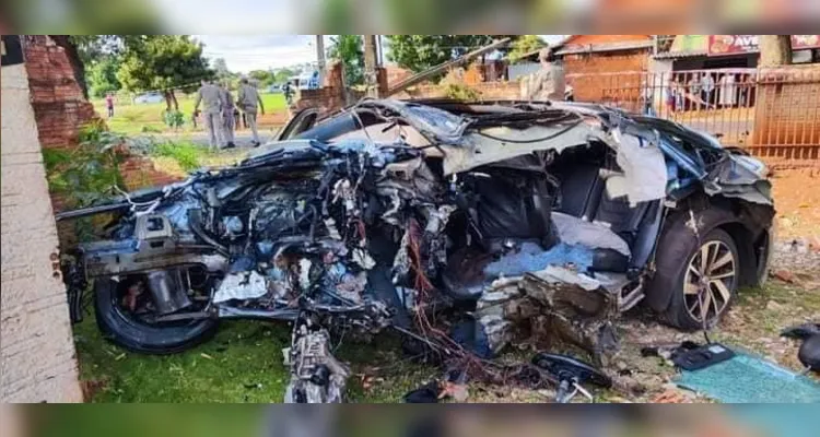 O carro ficou totalmente destruído após bater violentamente contra uma árvore e contra o muro de uma residência