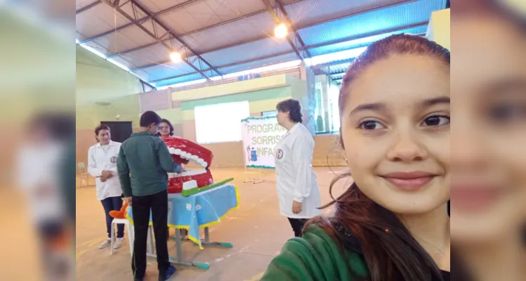 Self com um aluno juntamente com a dentista e sua assistente demonstrando como fazer a limpeza correta de seus dentes e melhorar sua higiene bucal - 5º ano A da Escola Prefeito Aristides Soares
