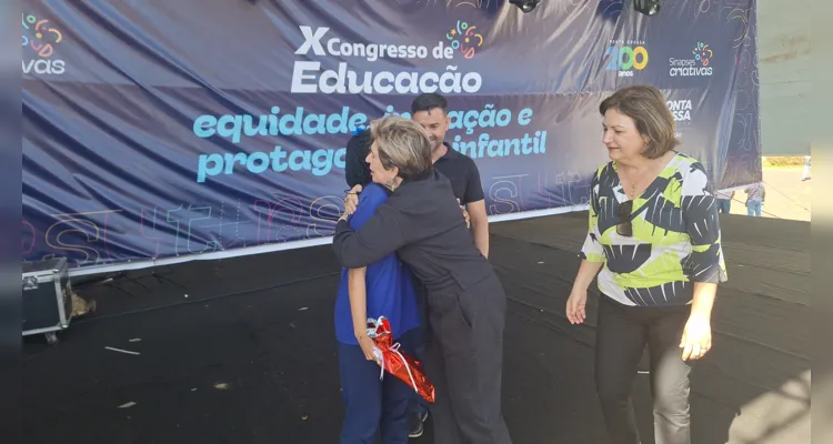 O aluno João recebendo o prêmio das mãos da prefeita Elizabeth Schmidt