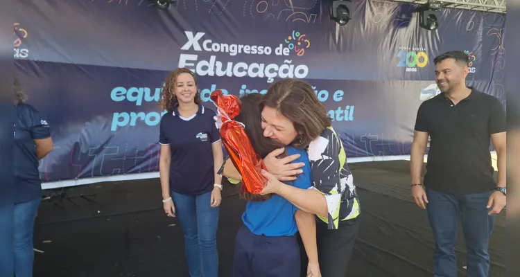 A aluna Ingridy ganhando as felicitações da secretária Simone Neves