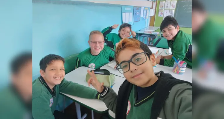 Selfie do aluno Pedro Miguel Alves com os colegas confeccionando o cartaz