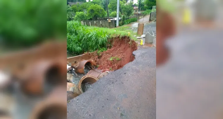 Excesso de água faz asfalto ceder e derruba parte de muro de casa