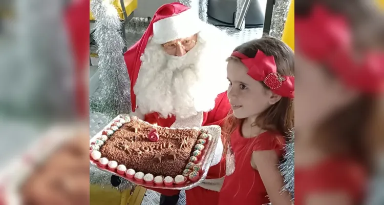 Papai Noel segura bolo de aniversário para Sophia   