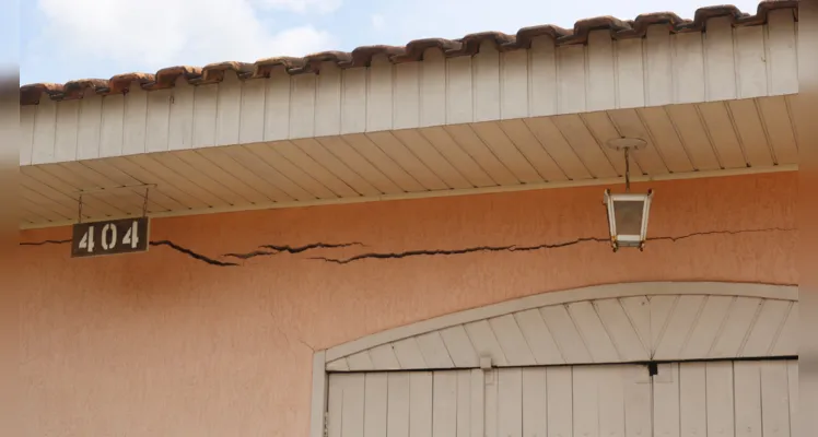 O dano foi tão intenso que provocou rachaduras na residência, no muro e já está próximo de alcançar a rua. 