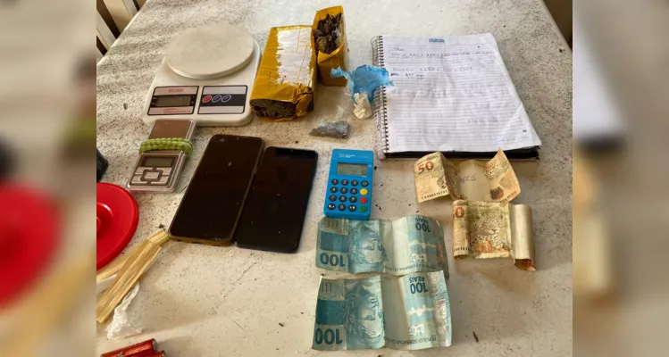 No local também foram encontrados 700 gramas de maconha, 5 gramas de cocaína, balança de precisão, caderno com anotações de tráfico e R$ 300.
