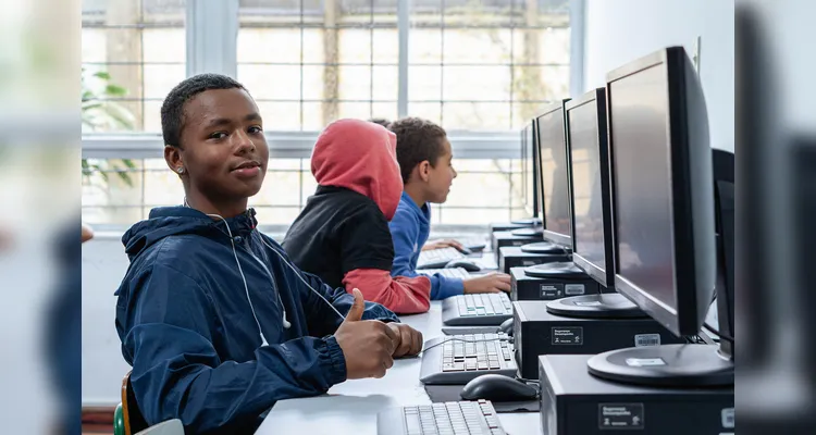 Na imagem, um jovem estuda pelo computador