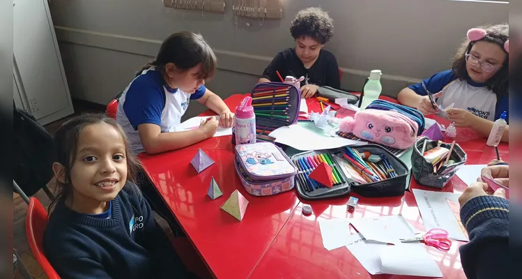 A turma utilizou modelos físicos, o livro didático e vídeos instrutivos para consolidar o aprendizado.