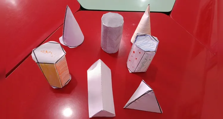 A turma utilizou modelos físicos, o livro didático e vídeos instrutivos para consolidar o aprendizado.