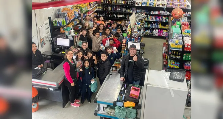A proposta consistia em cada alunos levar um valor em dinheiro, algo simbólico, para a turma realizar compras coletivas e experienciar na prática os conceitos estudados.