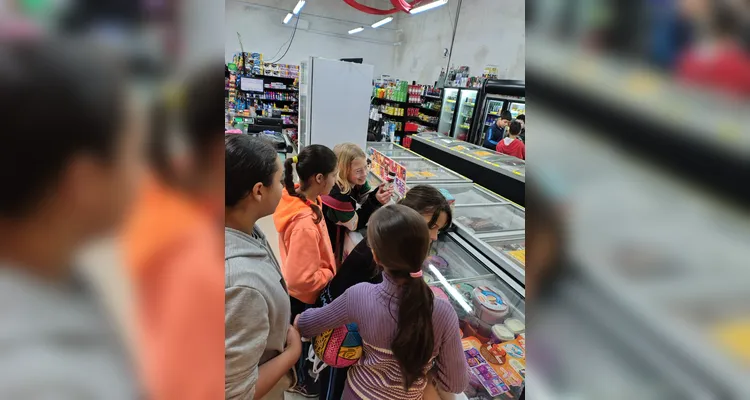 A proposta consistia em cada alunos levar um valor em dinheiro, algo simbólico, para a turma realizar compras coletivas e experienciar na prática os conceitos estudados.