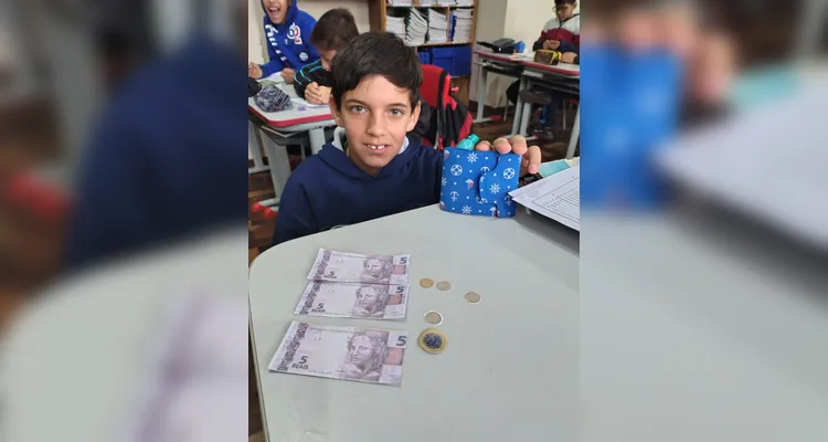 Em sala, a turma criou seu próprio sistema monetário. A ideia tem ajudado os alunos a seguirem acordos e se empenharem em atividades.