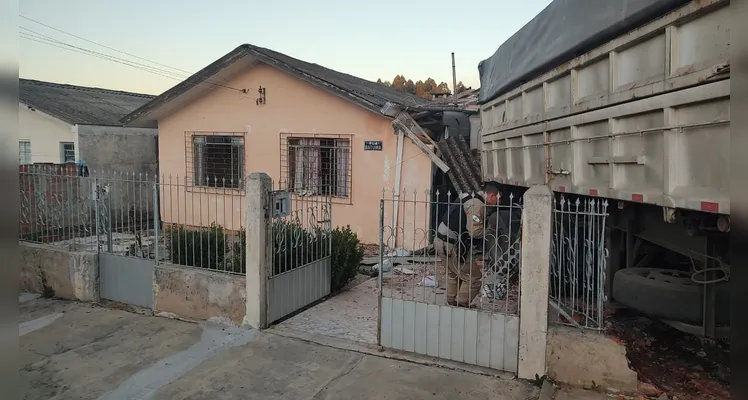 O caminhão acertou o carro estacionado na garagem, o que impediu que o veículo invadisse a cozinha da casa.
