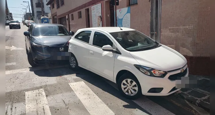Carro estacionado sem freio de mão atropela motorista e bate em veículo da frente.