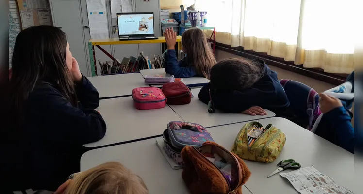 A classe usou variados recursos pedagógicos, como a videoaula do Vamos Ler e uma representação da pirâmide alimentar, e realizou trabalhos práticos sobre o tema.