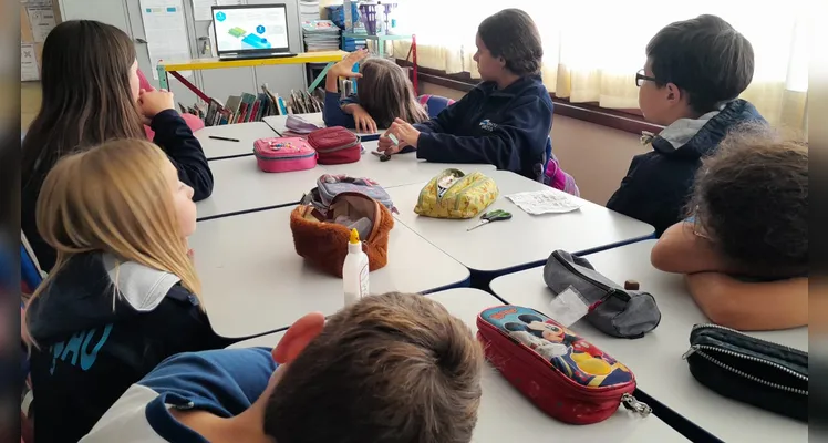 A classe usou variados recursos pedagógicos, como a videoaula do Vamos Ler e uma representação da pirâmide alimentar, e realizou trabalhos práticos sobre o tema.
