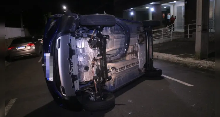 Carro colide contra veículo estacionado e tomba em PG; veja vídeo