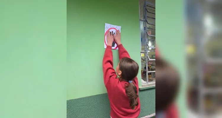 A classe realizou debates, confeccionou cartazes, distribuiu flores e mensagens positivas e gravou uma paródia educativa sobre o tema.