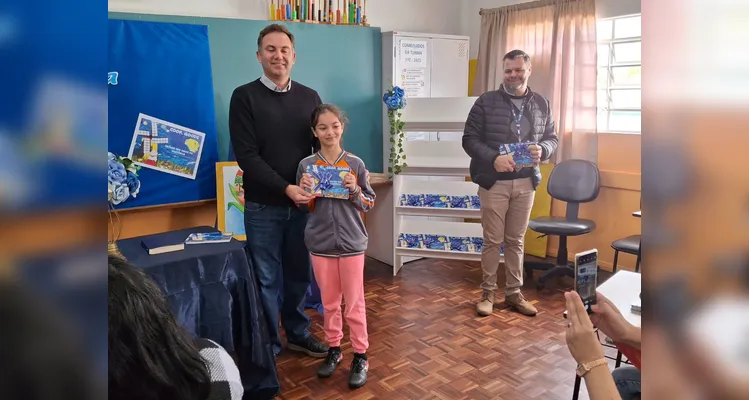 No evento de entrega dos materiais, cada aluno recebeu o seu exemplar e os familiares também estiveram presentes, assim como os representantes da Frísia Cooperativa.