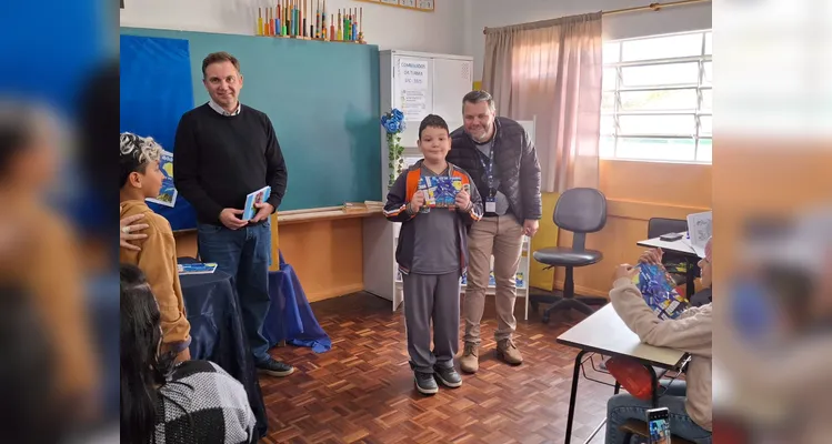 No evento de entrega dos materiais, cada aluno recebeu o seu exemplar e os familiares também estiveram presentes, assim como os representantes da Frísia Cooperativa.