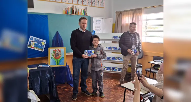 No evento de entrega dos materiais, cada aluno recebeu o seu exemplar e os familiares também estiveram presentes, assim como os representantes da Frísia Cooperativa.