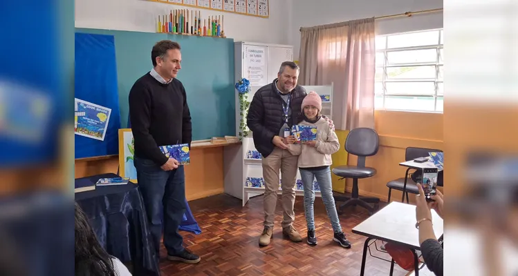 No evento de entrega dos materiais, cada aluno recebeu o seu exemplar e os familiares também estiveram presentes, assim como os representantes da Frísia Cooperativa.