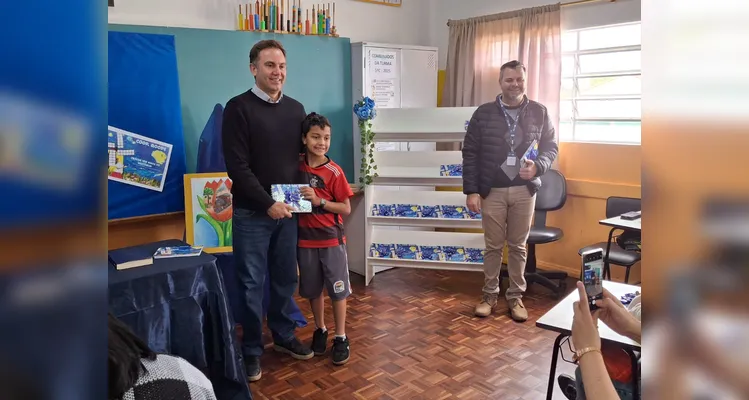 No evento de entrega dos materiais, cada aluno recebeu o seu exemplar e os familiares também estiveram presentes, assim como os representantes da Frísia Cooperativa.