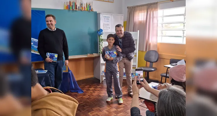 No evento de entrega dos materiais, cada aluno recebeu o seu exemplar e os familiares também estiveram presentes, assim como os representantes da Frísia Cooperativa.