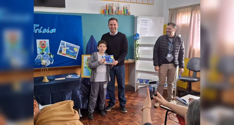 No evento de entrega dos materiais, cada aluno recebeu o seu exemplar e os familiares também estiveram presentes, assim como os representantes da Frísia Cooperativa.
