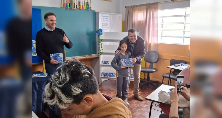 No evento de entrega dos materiais, cada aluno recebeu o seu exemplar e os familiares também estiveram presentes, assim como os representantes da Frísia Cooperativa.