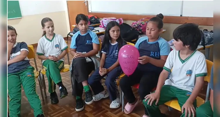 Para organizar a participação da turma, foi utilizada uma bexiga como “token de fala”: o aluno que recebia o objeto tinha a vez de contribuir com a narrativa e, em seguida, passava a bexiga para o colega.