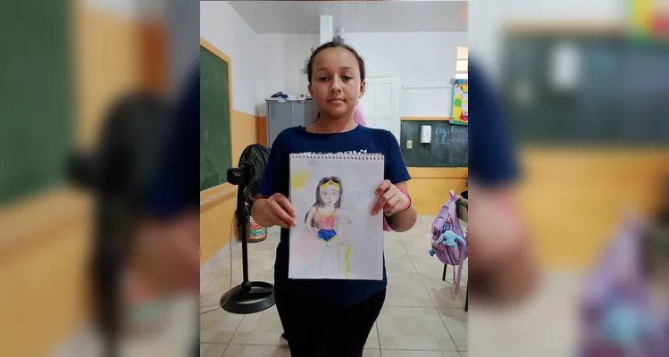 Os alunos produziram autorretratos imaginando-se como super-heróis e utilizaram vídeos de desenhistas como referência para representar personagens.