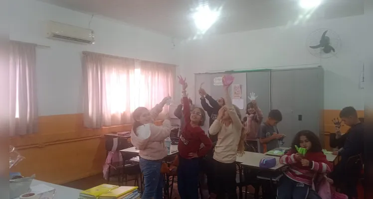Os alunos desenvolveram uma experiência de robótica "desplugada", utilizando materiais como EVA, canudinhos, cola e fios para confeccionar uma mão robótica.