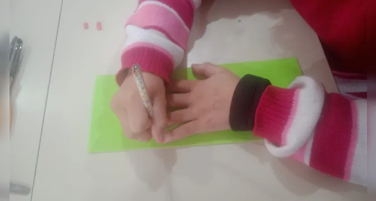 Os alunos desenvolveram uma experiência de robótica "desplugada", utilizando materiais como EVA, canudinhos, cola e fios para confeccionar uma mão robótica.