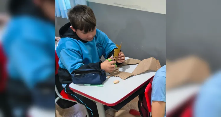 Utilizando materiais como papelão, canudos e barbante, os estudantes construíram uma mão robótica articulada.