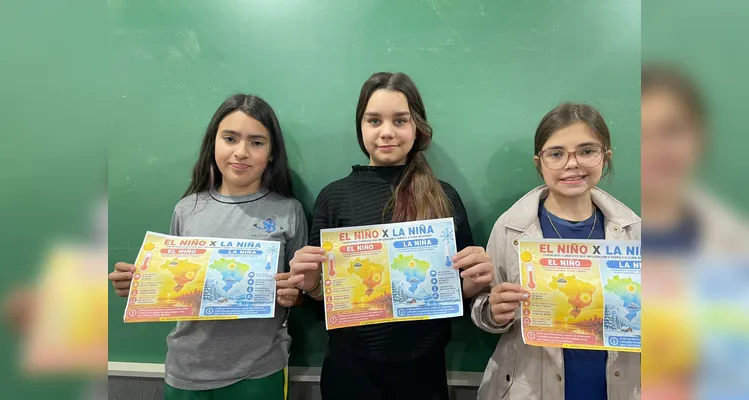 Os alunos apresentam cartazes sobre El Niño e La Niña, produzidos com apoio da inteligência artificial durante a atividade.