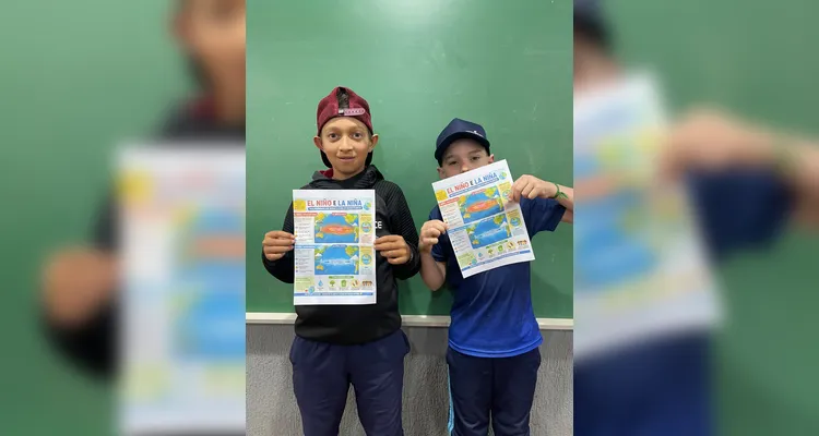 Os alunos apresentam cartazes sobre El Niño e La Niña, produzidos com apoio da inteligência artificial durante a atividade.
