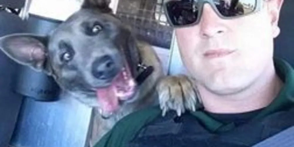 Foto mostra agente Doug Burgett e cão Zurki, da delegacia na Flórida