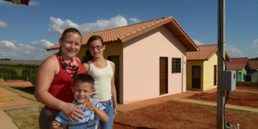 Na foto: Joice Graciele da Silva com os filhos Bryan e Emily na frente da nova casa.