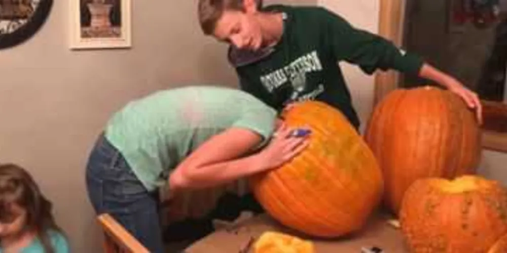 Imagem ilustrativa da imagem Jovem prende cabeça em abóbora ao fazer decoração de Halloween