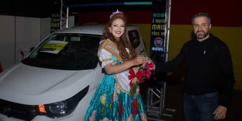 A rainha eleita recebendo a chave do Fiat Mobi das mãos do gerente comercial da Fiat CVL Ponta Grossa, Cleverson Barros
